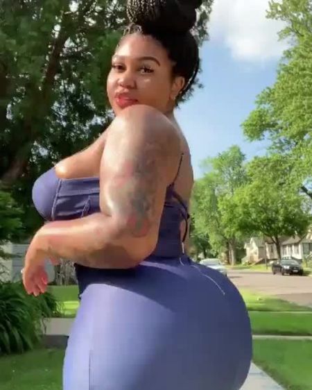 Mya Curvz in a purple top poses for a picture.